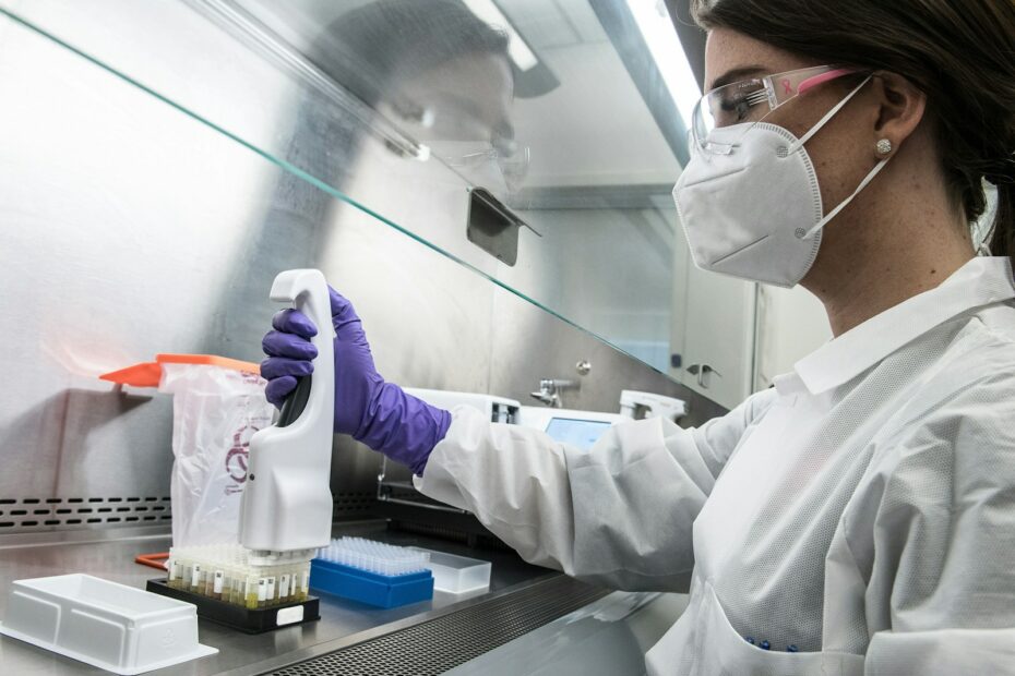 person in white gloves holding purple plastic bottle